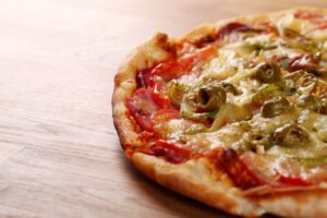 Dinkel-Pizza mit Schinken, Oliven und Paprika