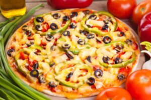 Dinkel-Pizza mit Tomaten, Oliven und Paprika