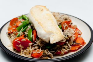 Tilapia mit Reis, Zuckerschoten, Möhre und Champignons