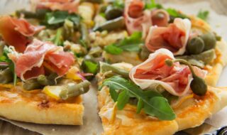 Dinkel-Pizza mit Parmaschinken, Oliven und Kapern
