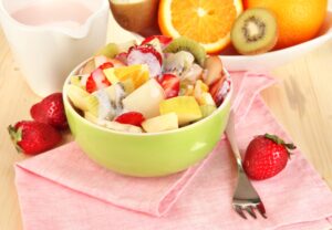 Obstsalat mit Erdbeeren, Orange, Apfel, Kiwi und Sojaoghurt