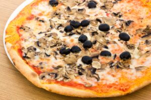 Pizza mit Champignons, Oliven und veganem Mozzarella