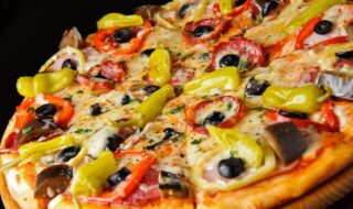 Pizza mit Paprika, Peperoni, Oliven und Salami